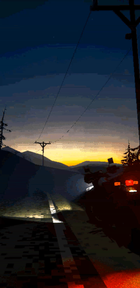 A motorcycle is parked on the side of a road in front of a mountain landscape view at dusk